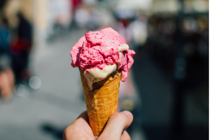 A pink and cream ice cream in a waffle cone