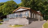 External of a lodge on pitch with decking and driveway space