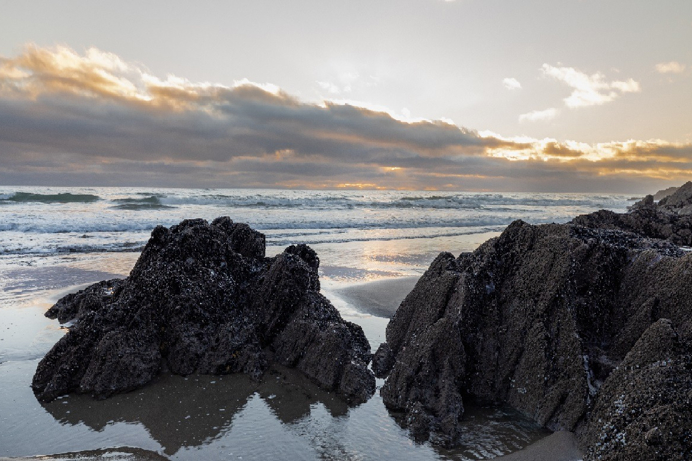 A rocky beach with the sea and moody low clouds in the background