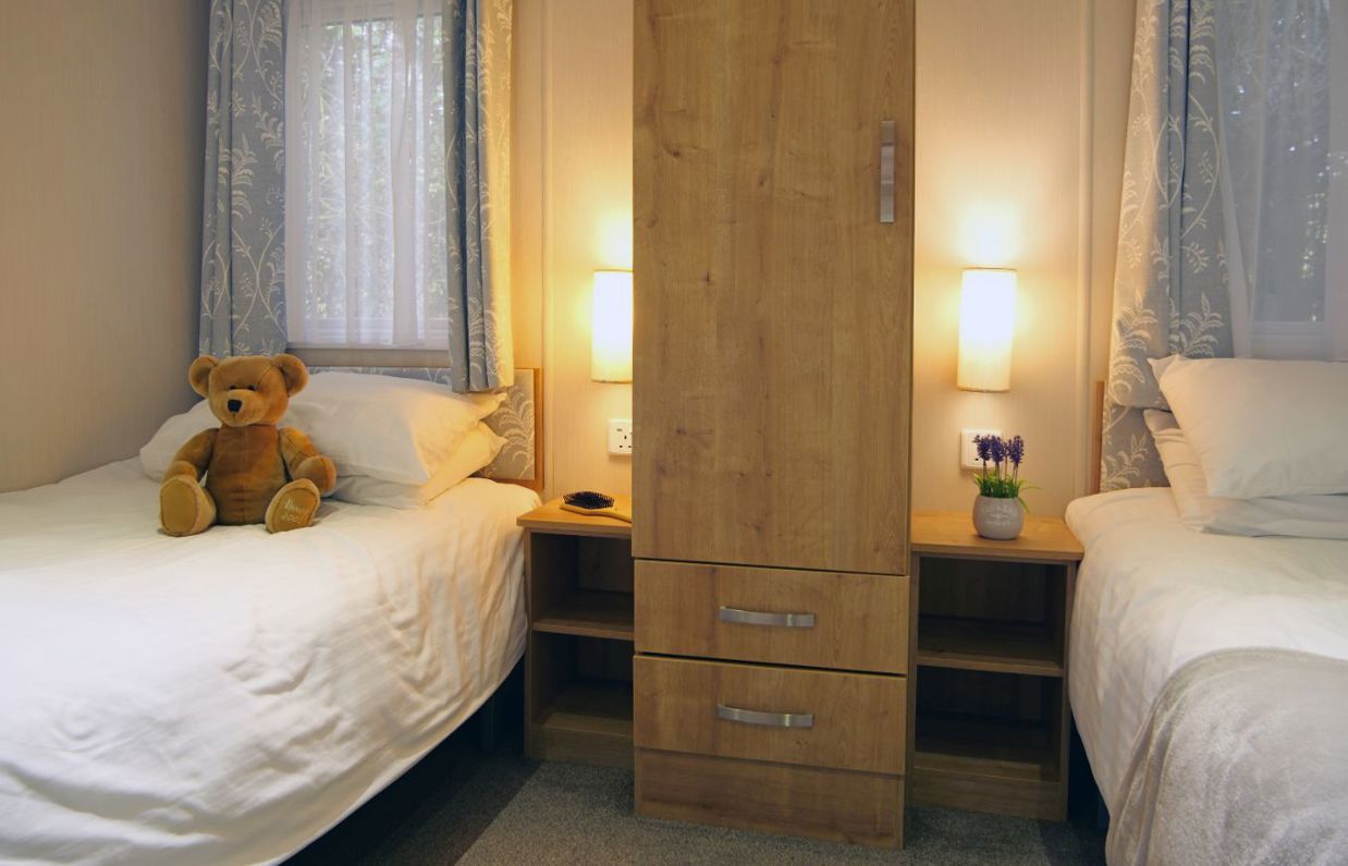 Internal of an accessible caravan spacious twin bedroom with storage