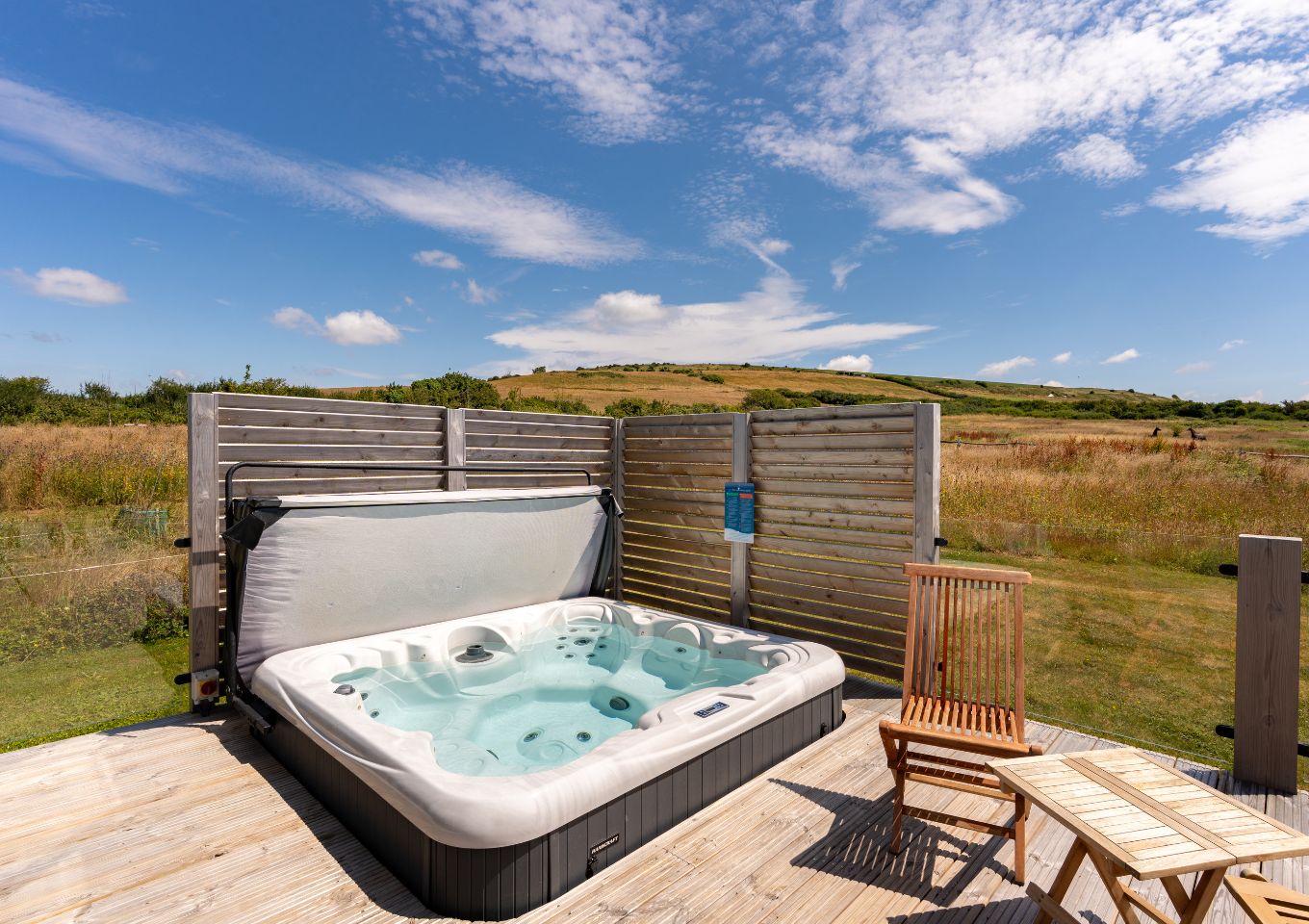 External of a cabin with decking, hot tub and outdoor furniture