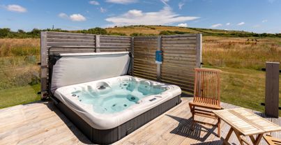 External of a cabin with decking, hot tub and outdoor furniture