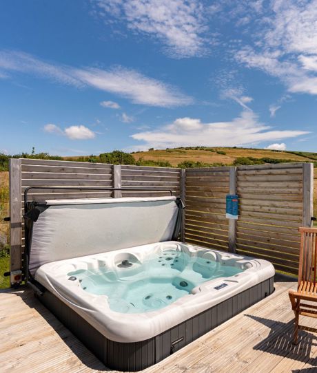 External of a cabin with decking, hot tub and outdoor furniture