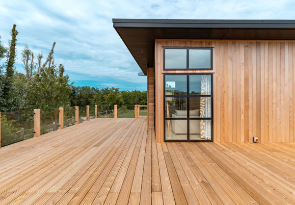 External of a luxury lodge on pitch with extensive decking and green space