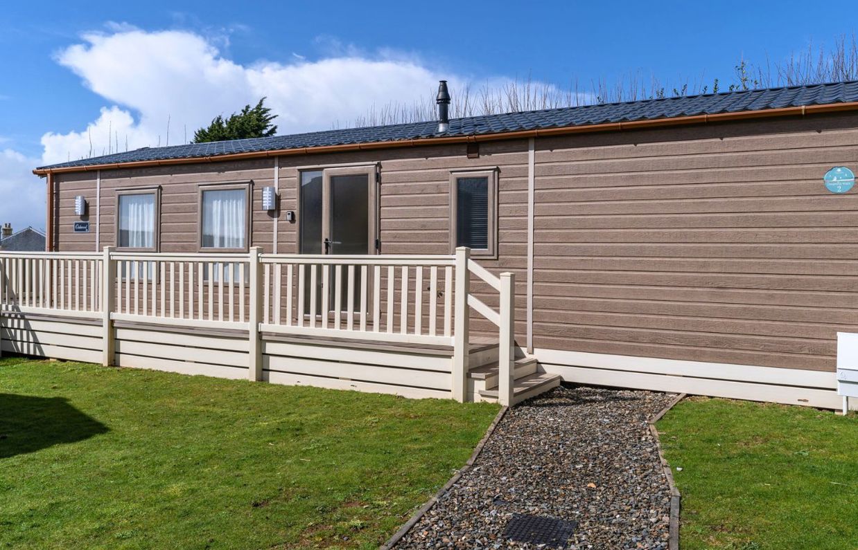 External of a caravan on pitch with decking and a pathway