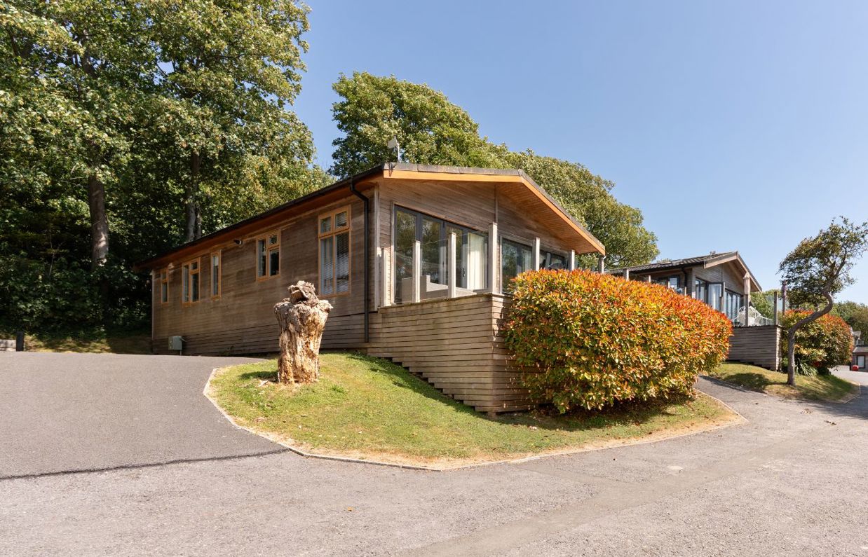 External of a lodge on pitch with decking and driveway space