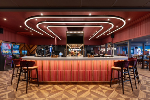 Internal of the Arena Sports Bar striking U-shaped bar with bar stools and dramatic lighting