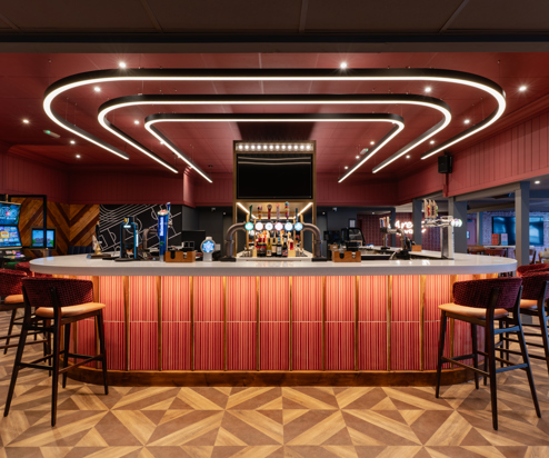 Internal of the Arena Sports Bar striking U-shaped bar with bar stools and dramatic lighting