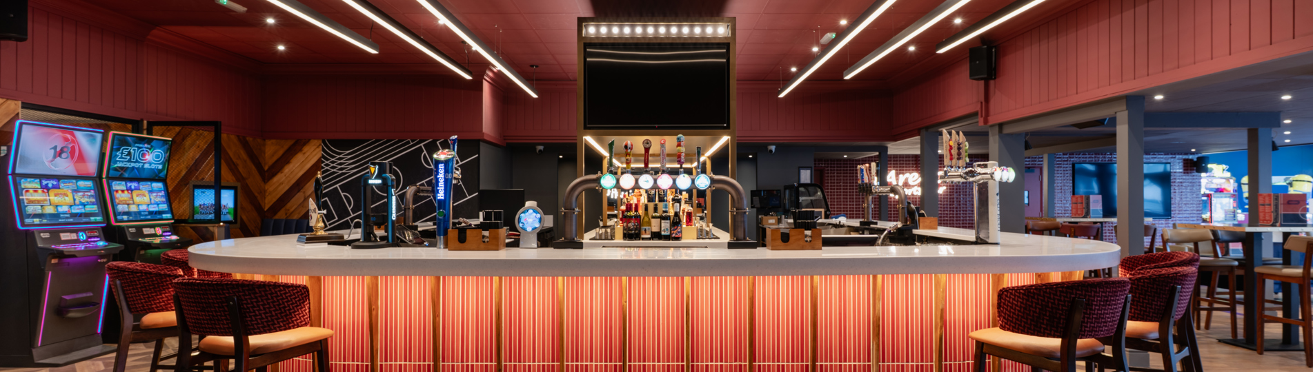 Internal of the Arena Sports Bar striking U-shaped bar with bar stools and dramatic lighting