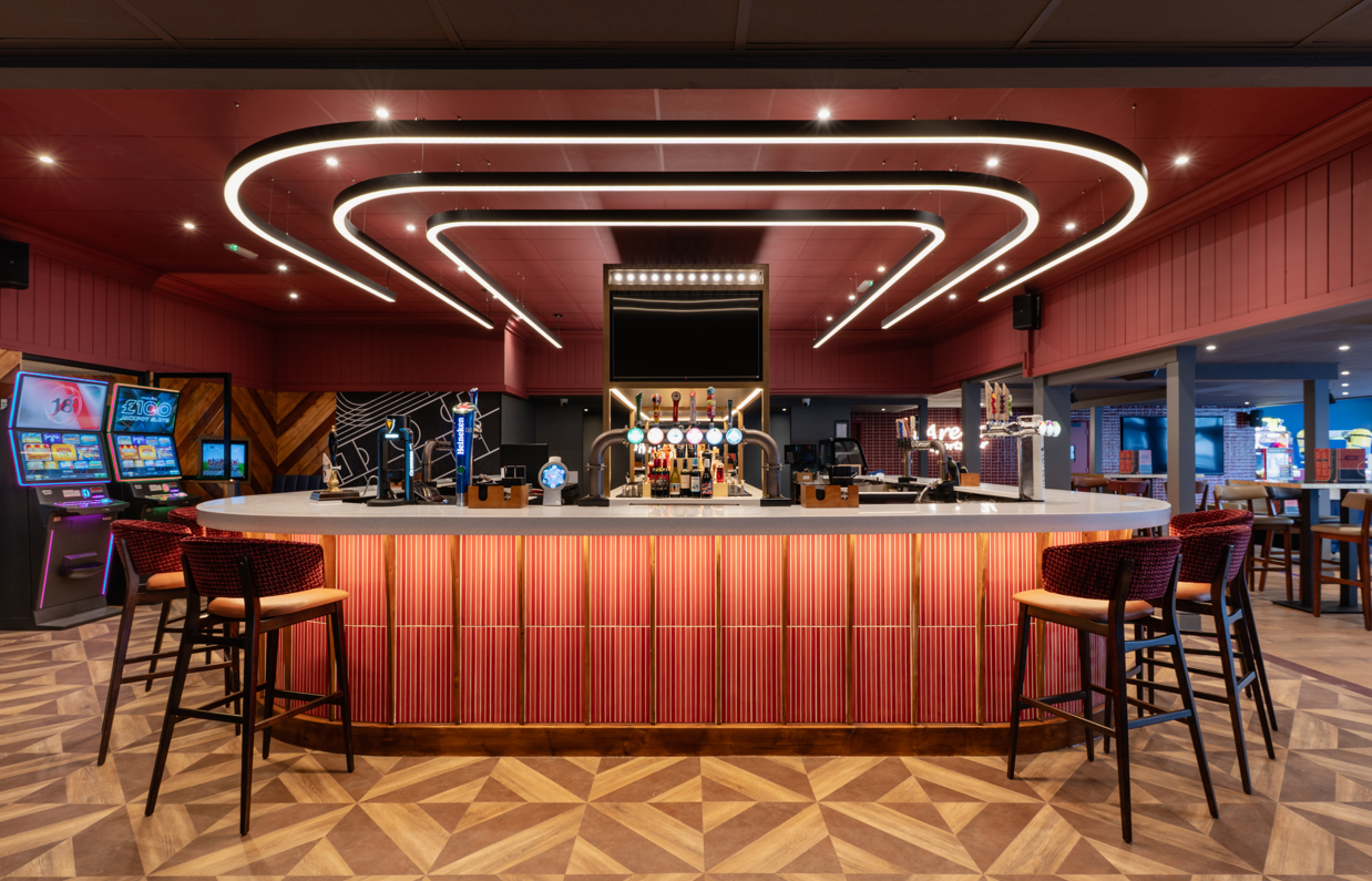 Internal of the Arena Sports Bar striking U-shaped bar with bar stools and dramatic lighting