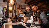 A family of four stood at the bar in Stargazy Bar & Grill with a dalmatian stood up on its back legs