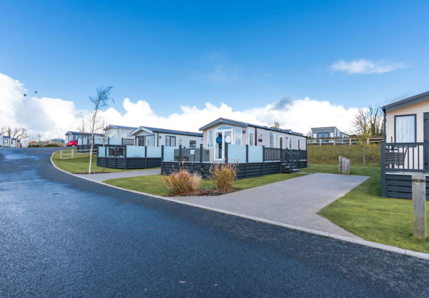 External of a caravan on pitch with decking and a parking space 