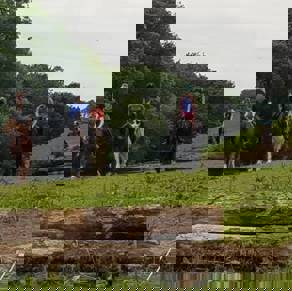 A group of people on ponies and horses trekking through fields