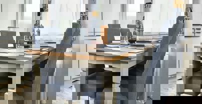 Standalone dining table with comfy grey chairs set for dinner for four