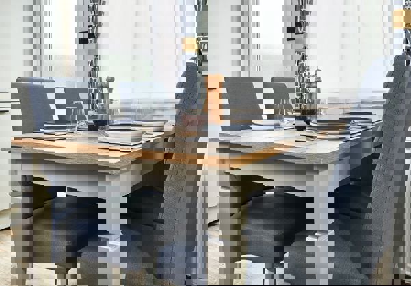 Standalone dining table with comfy grey chairs set for dinner for four