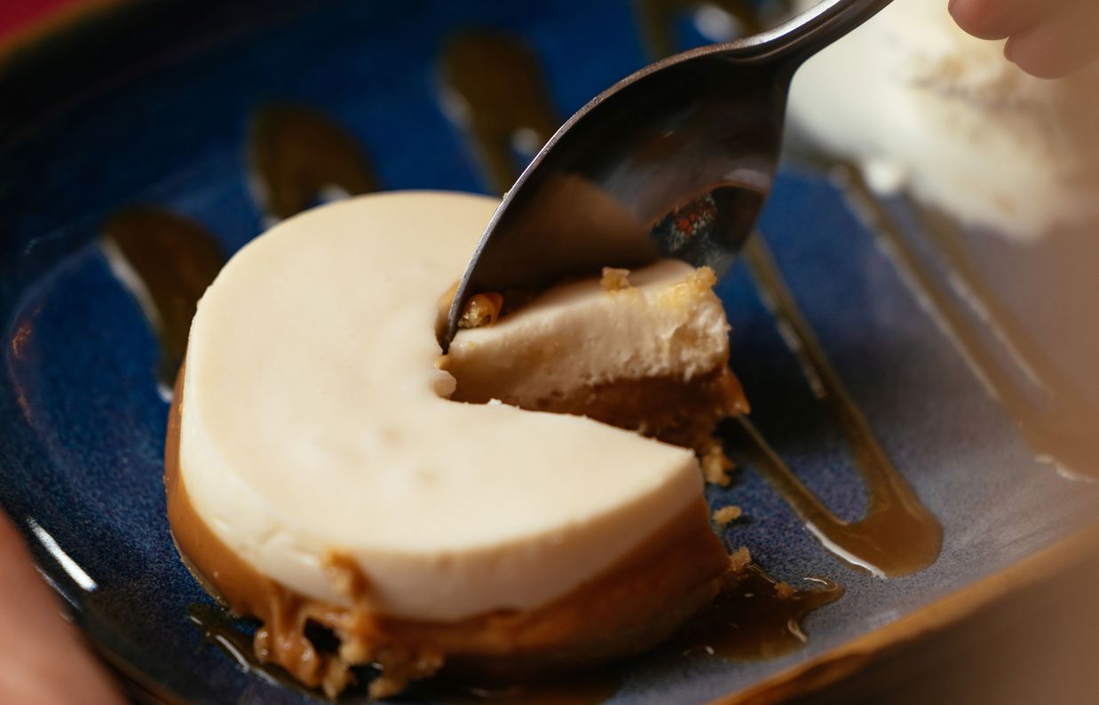A creamy dessert with a bite taken out of it being scooped with a spoon