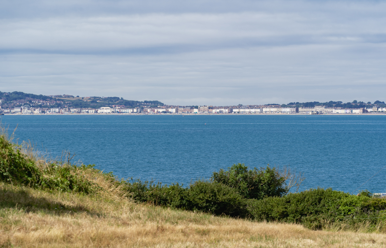 The view of the sea and Weymouth through countryside from Osmington Mills Lodge Park