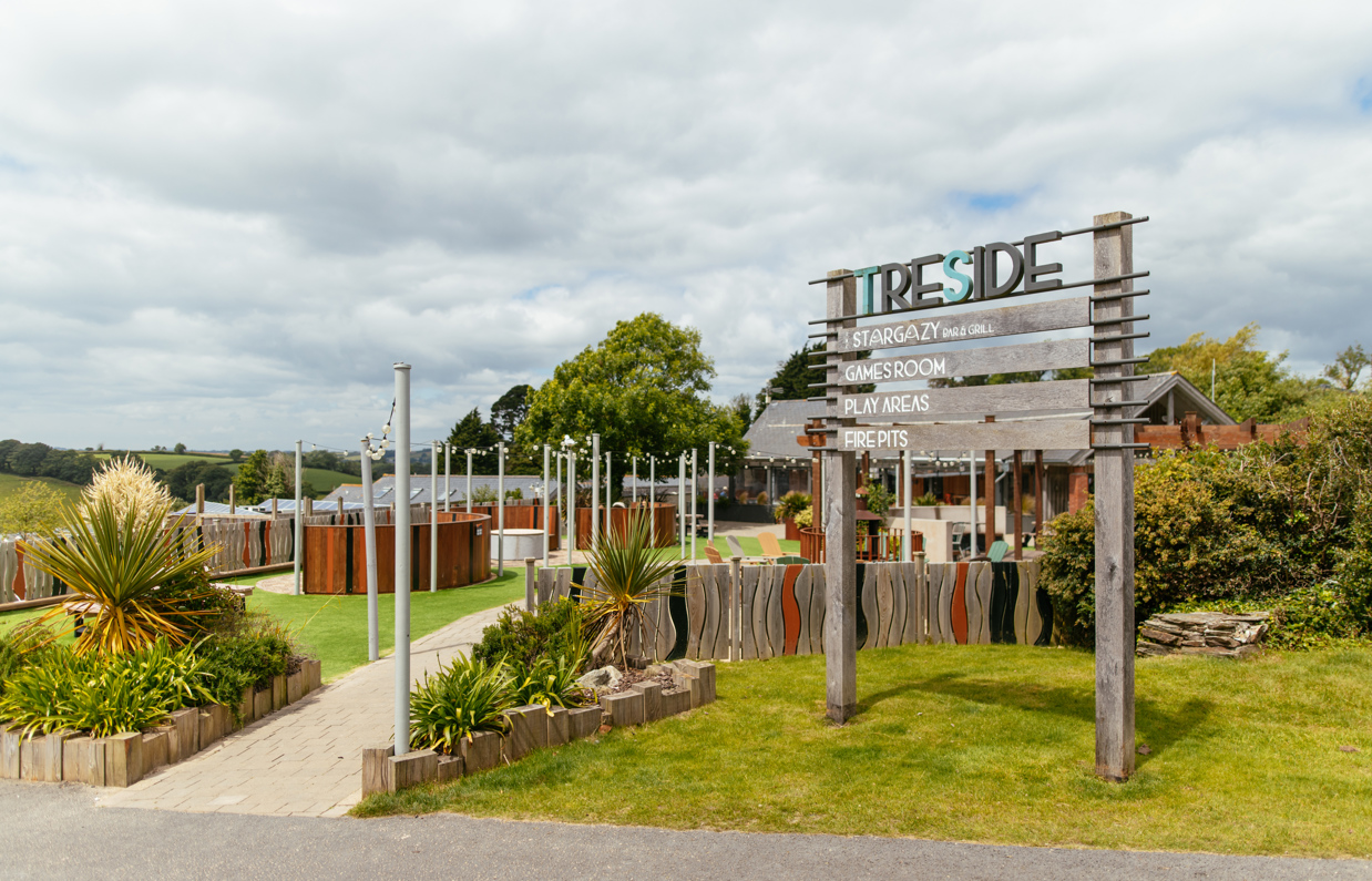 A wooden sign of the 'Treside' area with stargazy, games room, arcade and fire pits at Tregoad Holiday Park