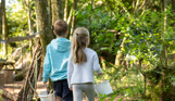 A young boy and girl walking in the woods with buckets