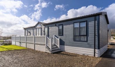 External of a caravan on pitch with decking and parking space