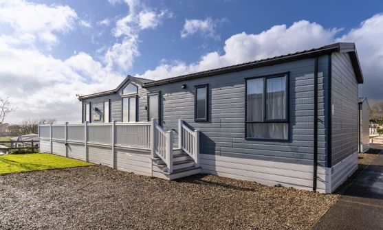 External of a caravan on pitch with decking and parking space
