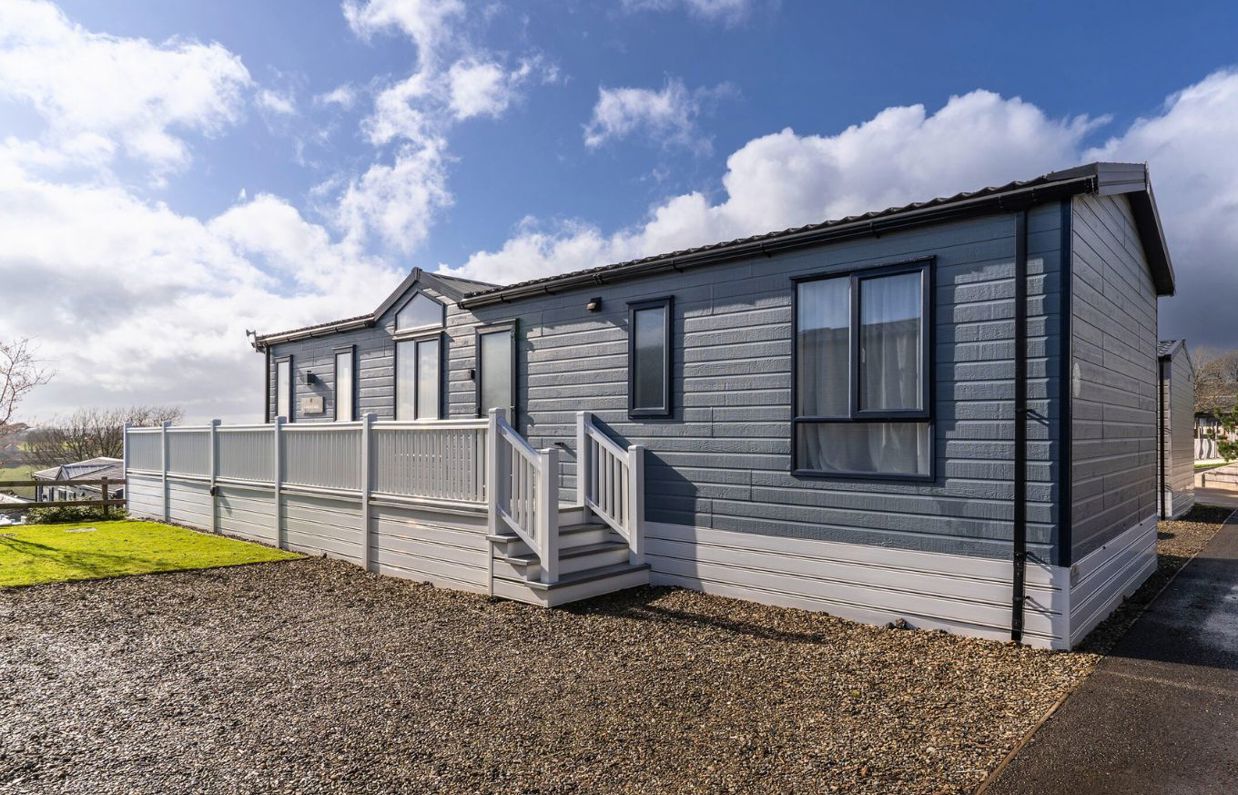 External of a caravan on pitch with decking and parking space