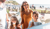 Family excitedly getting ice creams in sunshine