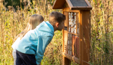 A young boy and girl looking for wildlife in a nature habitat among woodland