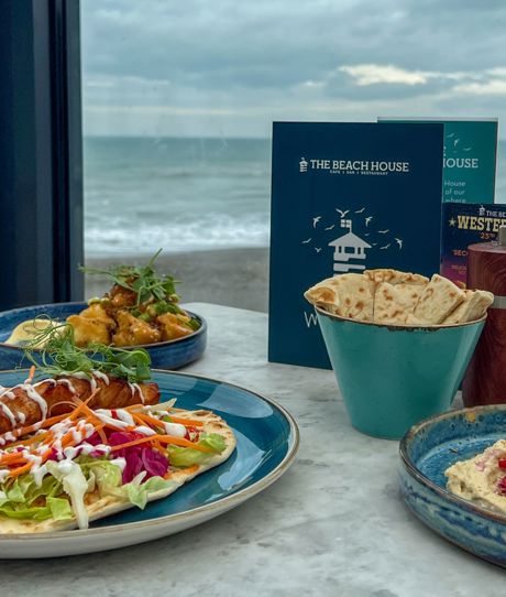 A selection of food dishes on a table at The Beach House Seaton with sea views