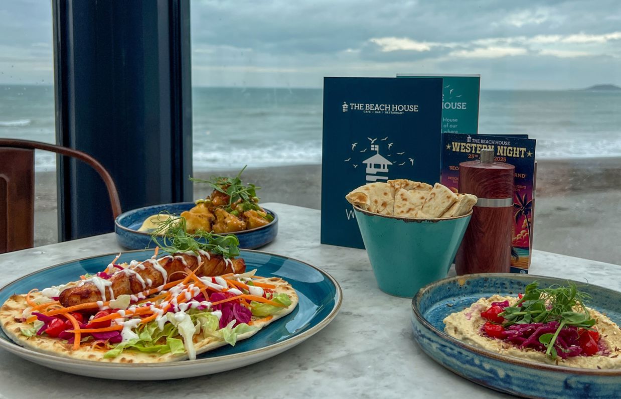 A selection of food dishes on a table at The Beach House Seaton with sea views