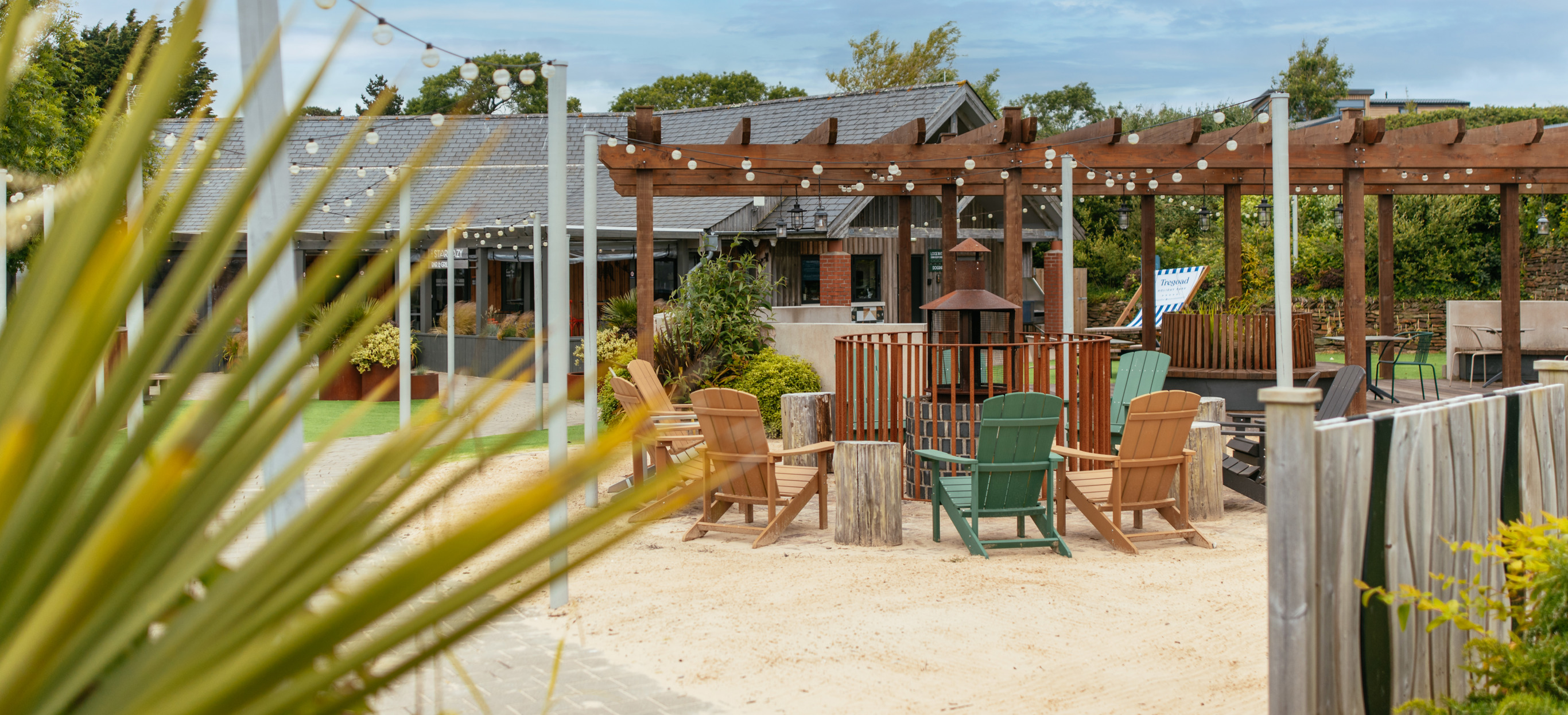 Outdoor seating at Stargazy with a fire pit under a veranda and fairy lights