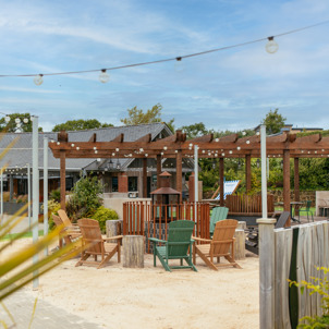 Outdoor seating at Stargazy with a fire pit under a veranda and fairy lights