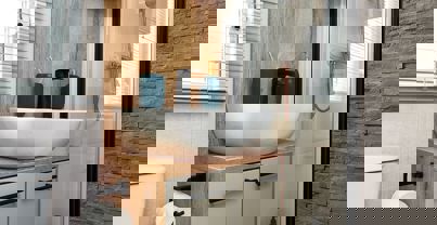 Modern shower room with large sink and shower, soft grey tiles, natural wood splashback and black fixtures