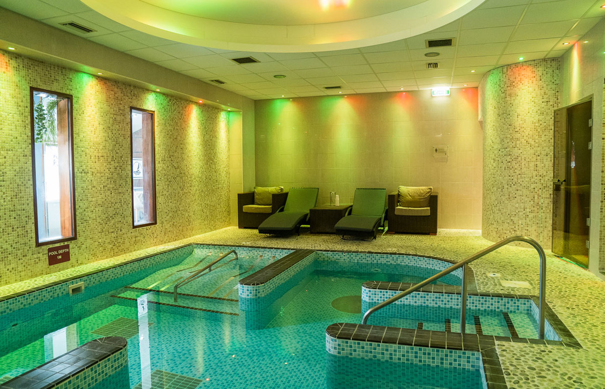 A hydrotherapy pool with loungers and calm lights