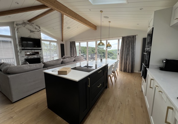 Modern open-plan kitchen island overlooking the lounge with large fireplace