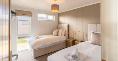 Twin Room with muted tone decor and large window