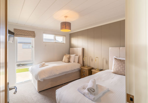 Twin Room with muted tone decor and large window