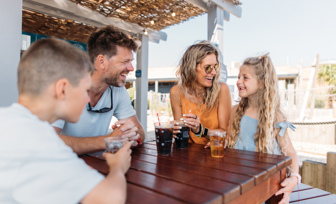 Family of four having drinks at The Shack at Bowleaze Cove in the sunshine