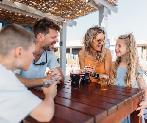 Family of four having drinks at The Shack at Bowleaze Cove in the sunshine
