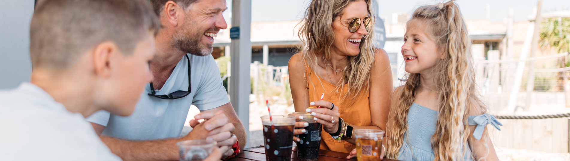 Family of four having drinks at The Shack at Bowleaze Cove in the sunshine