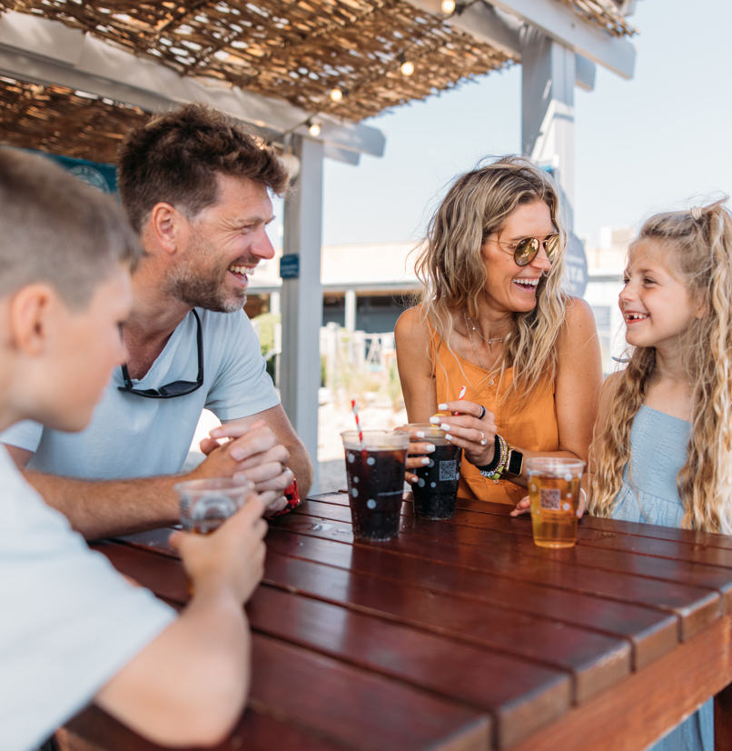 Family of four having drinks at The Shack at Bowleaze Cove in the sunshine