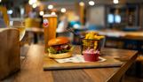 A burger, chips and coleslaw with a pint and a glass of wine in a table at Breeze Bar & Grill