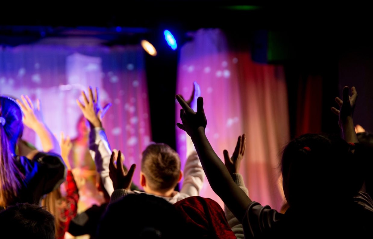 A group of people with their hands in the air in an entertainment venue