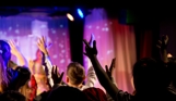 A group of people with their hands in the air in an entertainment venue