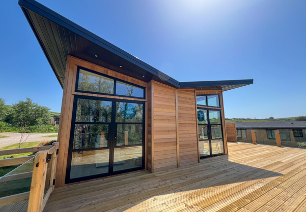 External of a luxury lodge on pitch with decking and angel wing roof