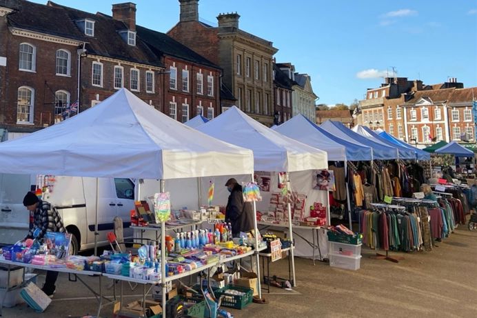 A row of market stalls in a town on a sunny day