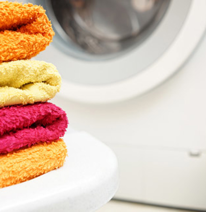A washing machine with towels and laundry detergent