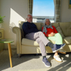 A couple sat together on a sofa in a caravan