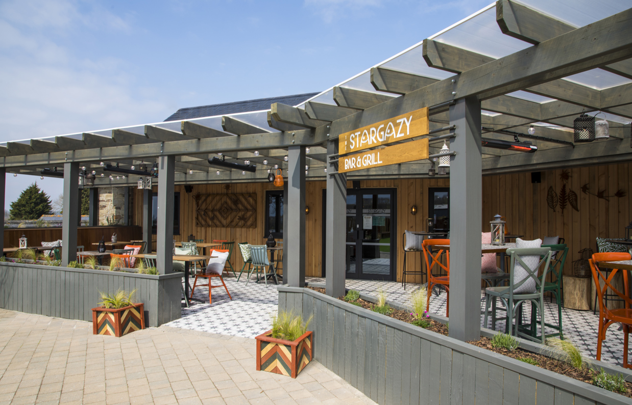 The outside and entrance of Stargazy Bar & Grill with seating