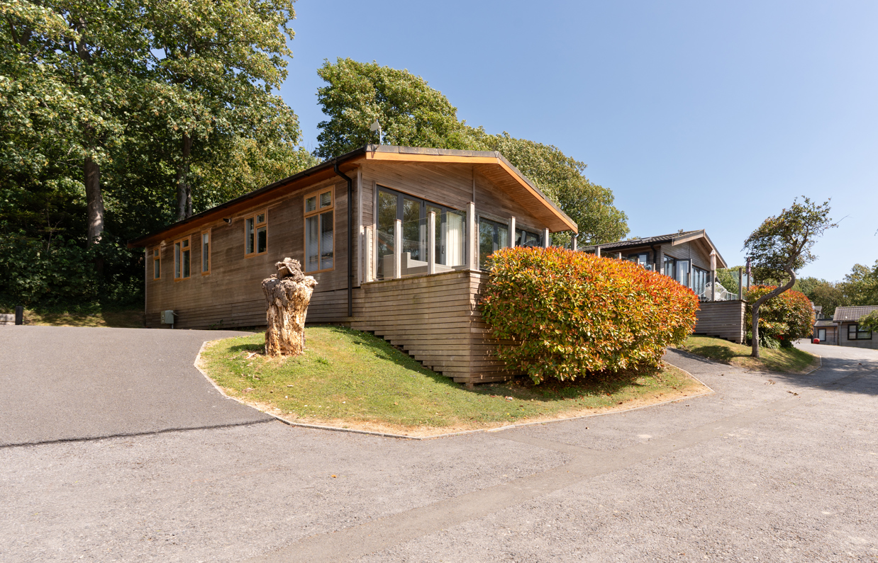 A row of lodges on a lodge park surrounded by trees on a sunny, blue sky day